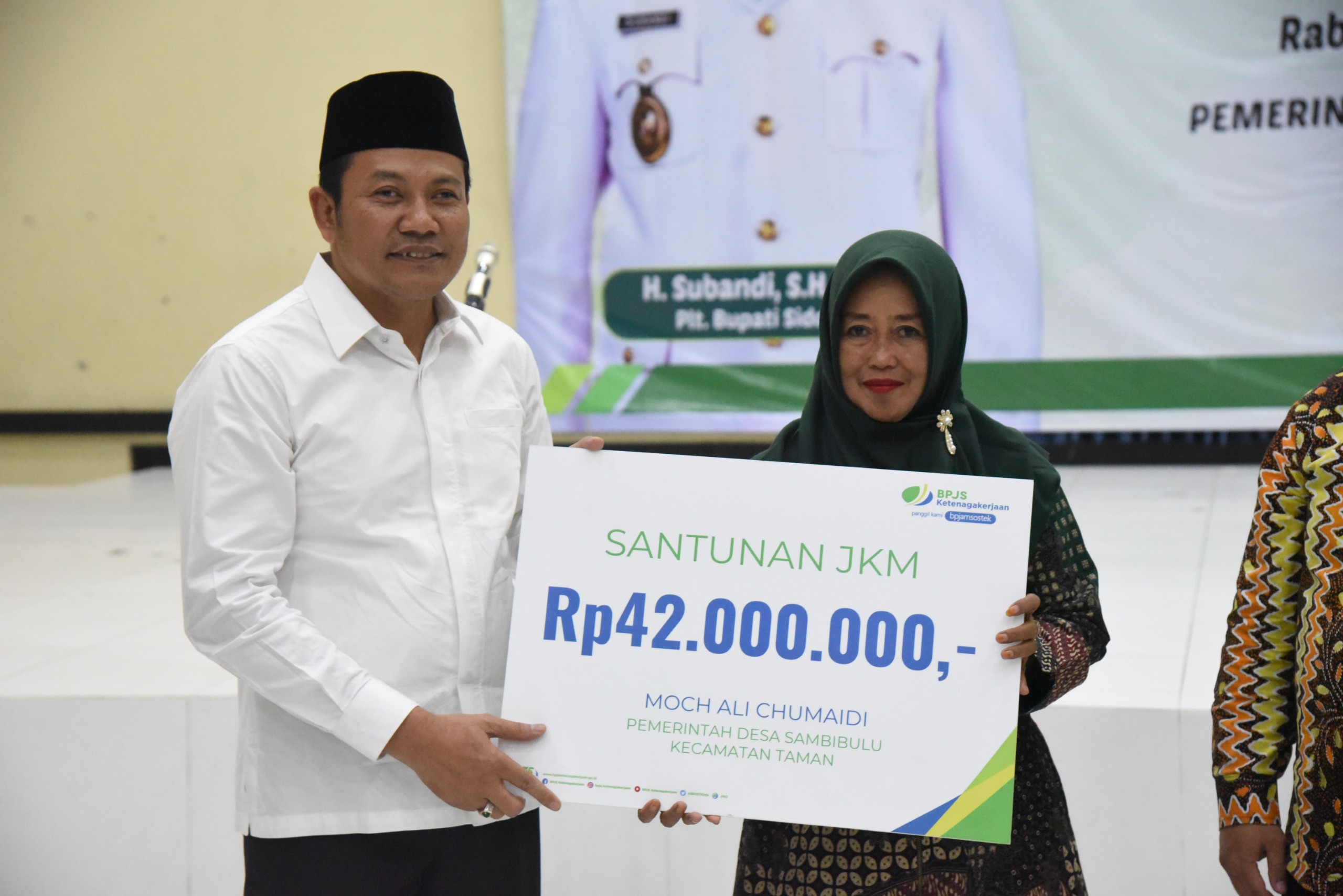 SERAHKAN - Plt Bupati Sidoarjo, Subandi menyerahkan jaminan sosial BPJS Ketenagakerjaan untuk RT dan RW di Desa Kedungturi, Kecamatan Taman, Sidoarjo, Rabu (18/09/2024) malam. 