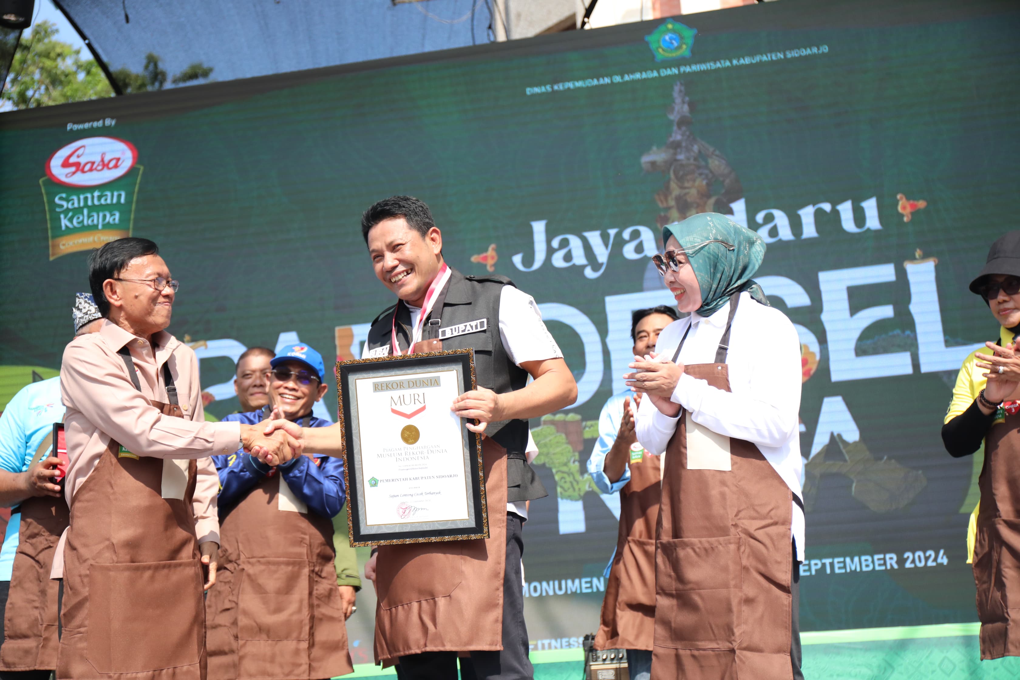 MURI - Plt Bupati Sidoarjo, Subandi menerima penghargaan Rekor MURI atas penyajian 1.500 porsi Lontong Cecek dalam acara Jayandaru Parade Selera Rasa Nusantara di Alun-Alun Sidoarjo, Minggu (22/09/2024). 