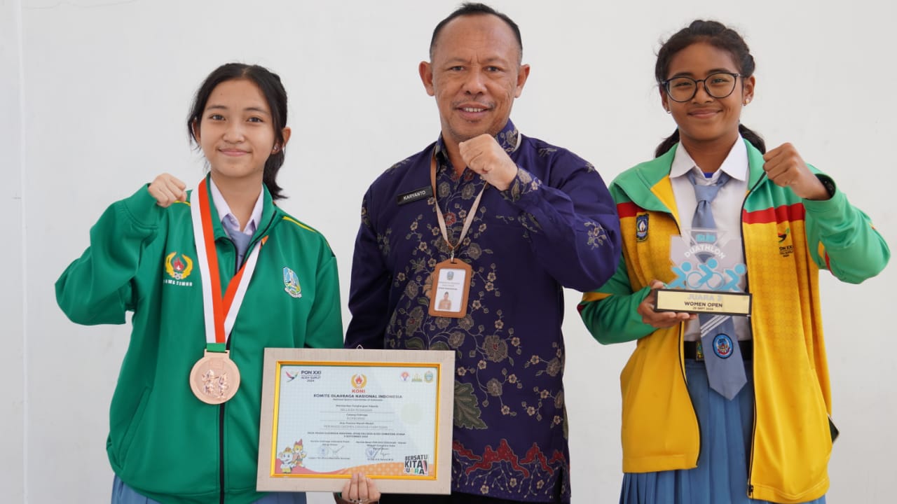 SUMBANG PERUNGGU - Siswi SMAN 4 Sidoarjo, Bellinda Revandari saat berfoto bersama temannya dan Kepala SMAN 4 Sidoarjo, Dr Karyanto sembari menunjukkan medali perunggu yang diraihnya, Rabu (02/10/2024).