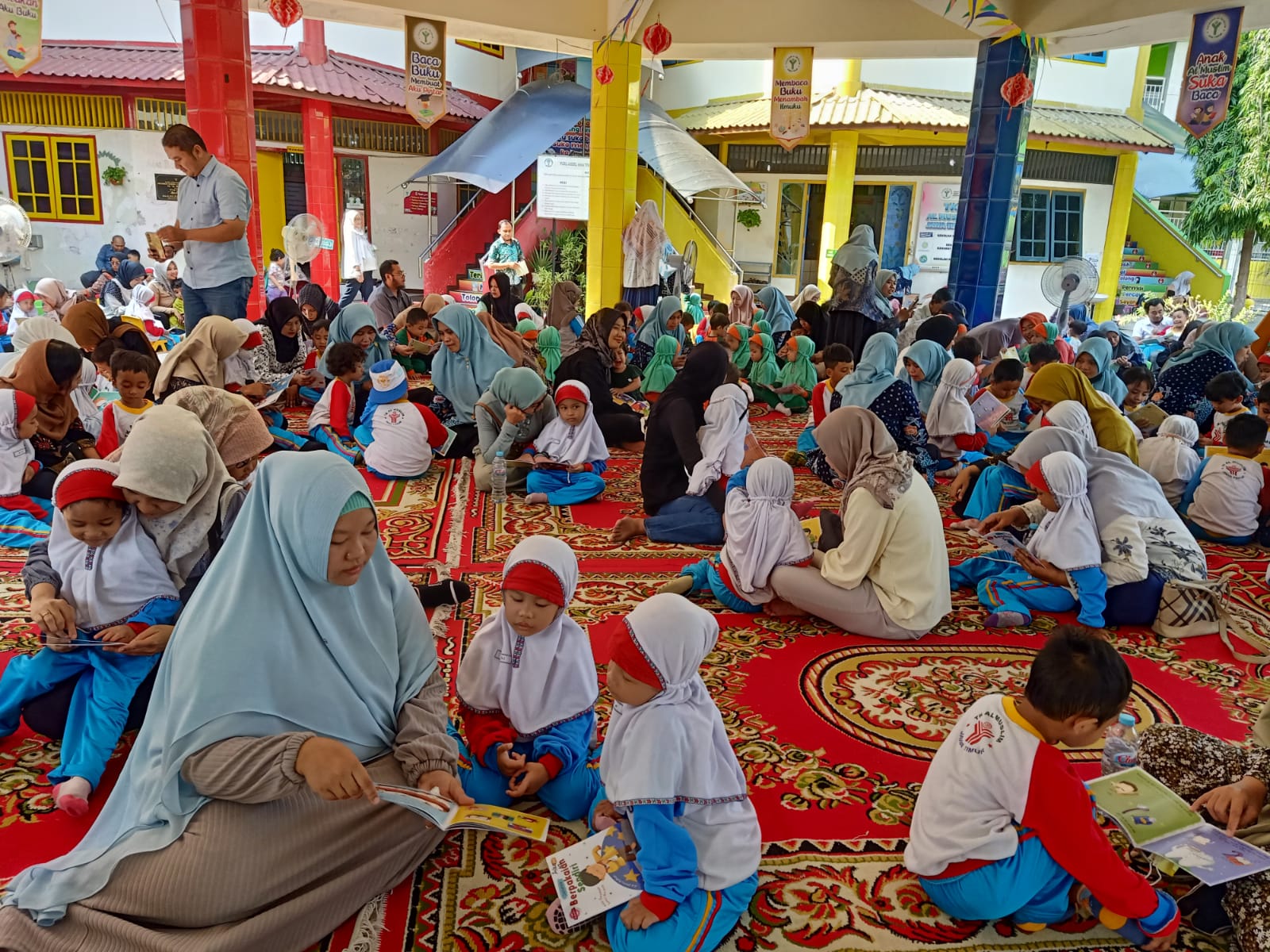 BACA BUKU - Para orang tua dan wali murid siswa dan siswi KB TK Al Muslim membacakan buku untuk putra dan putri di sejumlah tempat di komplek KB TK Al Muslim untuk peringatan Bulan Bahasa yang jatuh setiap Bulan Oktober, Jumat (25/10/2024).