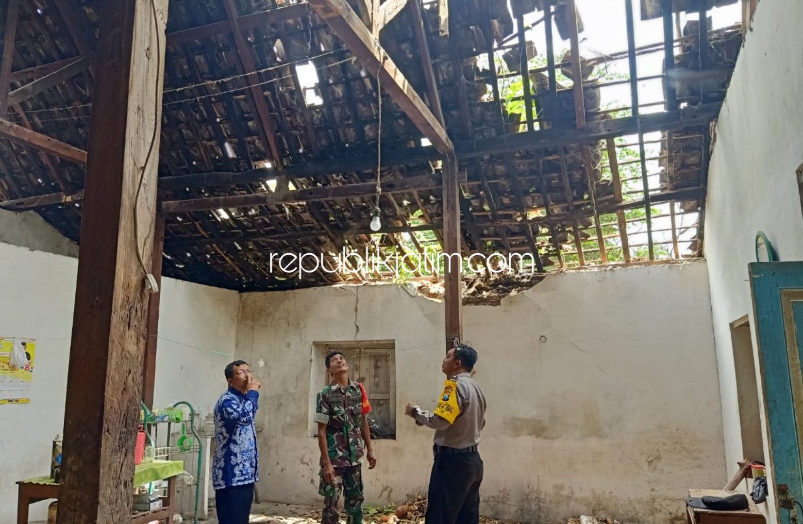 POHON TUMBANG - Warga, perangkat desa serta anggota TNI dan Polri kerja bakti mengevakuasi pohon tumbang yang menimpa rumah Mbah Kitin warga Desa Jabung, Kecamatan Mlarak, Ponorogo, Kamis (02/01/2020).