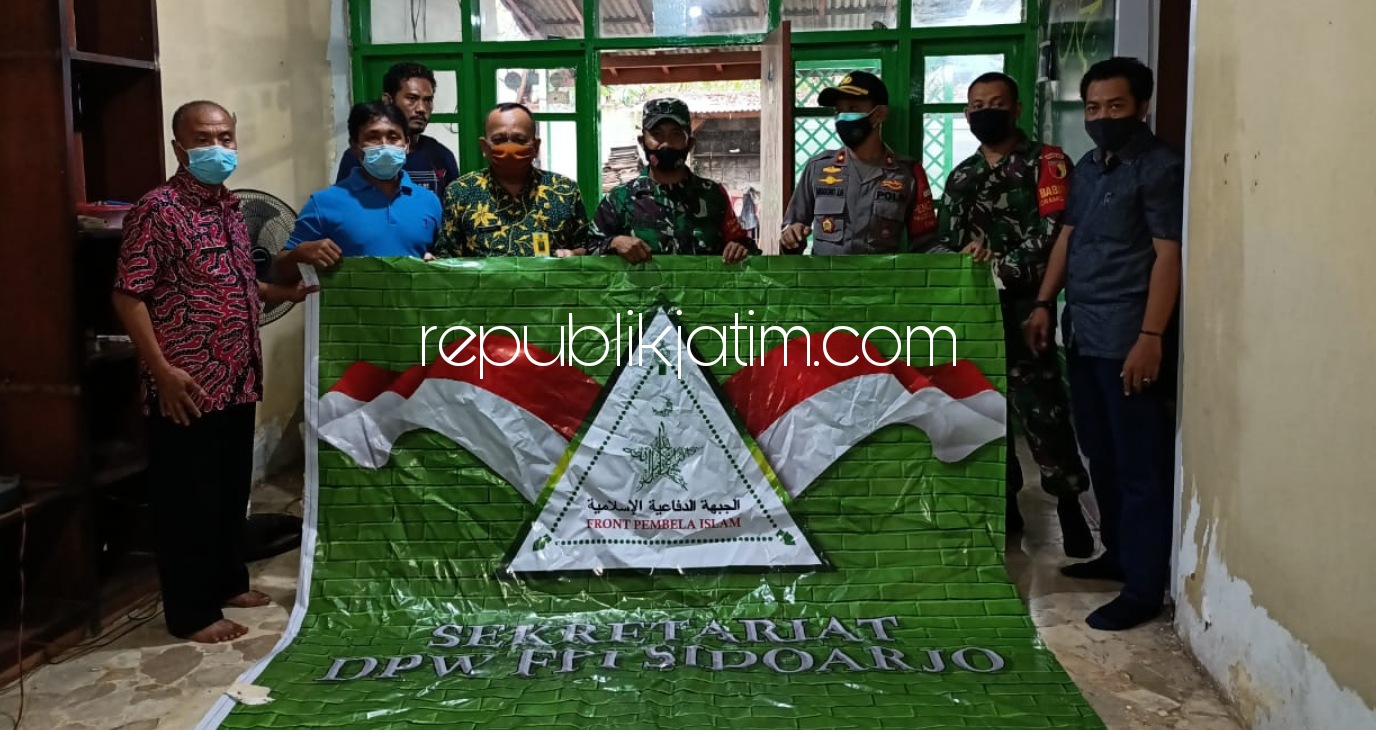 AMANKAN - Sejumlah petugas gabungan mengamankan sejumlah atribut Front Pembela Islam (FPI) yang ada di Perumahan Wisma Delta, Plipir, Kelurahan Sekardangan, Kecamatan Sidoarjo, Selasa (05/01/2021) sore.