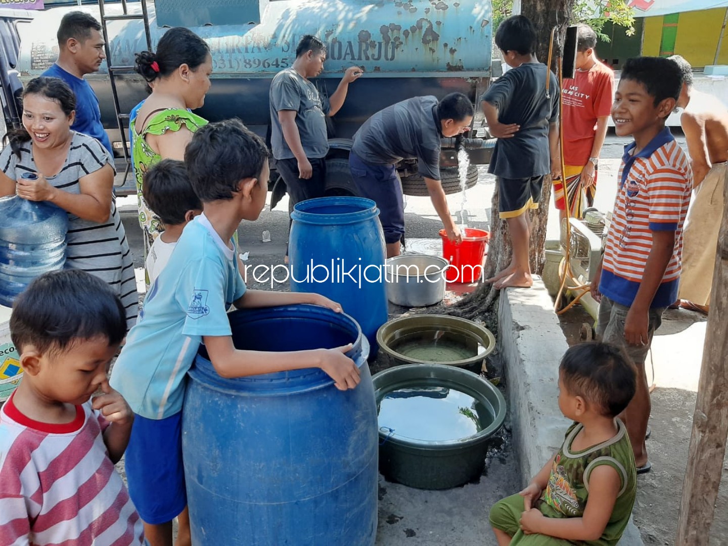 REBUTAN - Puluhan warga korban puting beliung Dusun Sidorono, Desa Barengkrajan, Kecamatan Krian, Sidoarjo berebut pasokan air bersih 5.000 liter dari PDAM Delta Tirta Sidoarjo, Senin (06/01/2020).