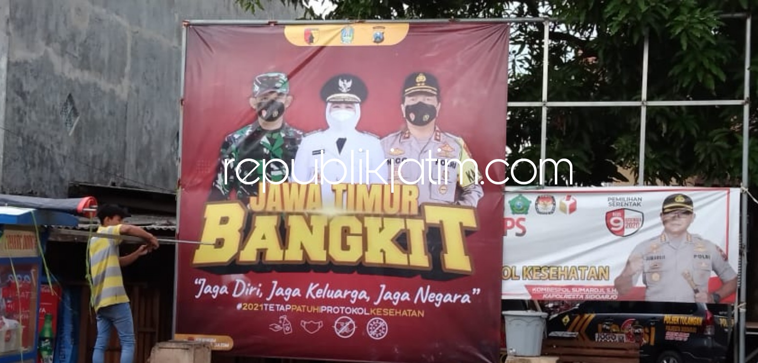 BANNER - Menjelang Pemberlakuan Pembatasan Kegiatan Masyarakat (PPKM) dalam rangka mencegah penyebarluasan Covid-19 di berbagai wilayah Sidoarjo, personel Polresta Sidoarjo memasang banner himbauan untuk masyarakat, Minggu (10/01/2021).