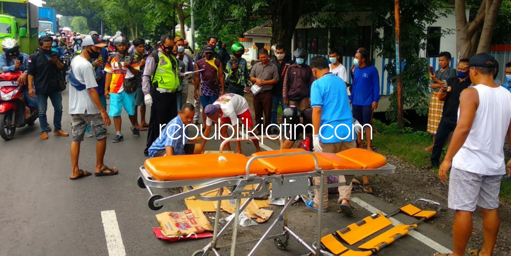 EVAKUASI - Warga dan petugas mengevakuasi jenazah, Heni Rosida warga Perum Sidorejo, Kecamatan Krian, Sidoarjo yang tewas tertabrak bus, Selasa (12/01/2021).