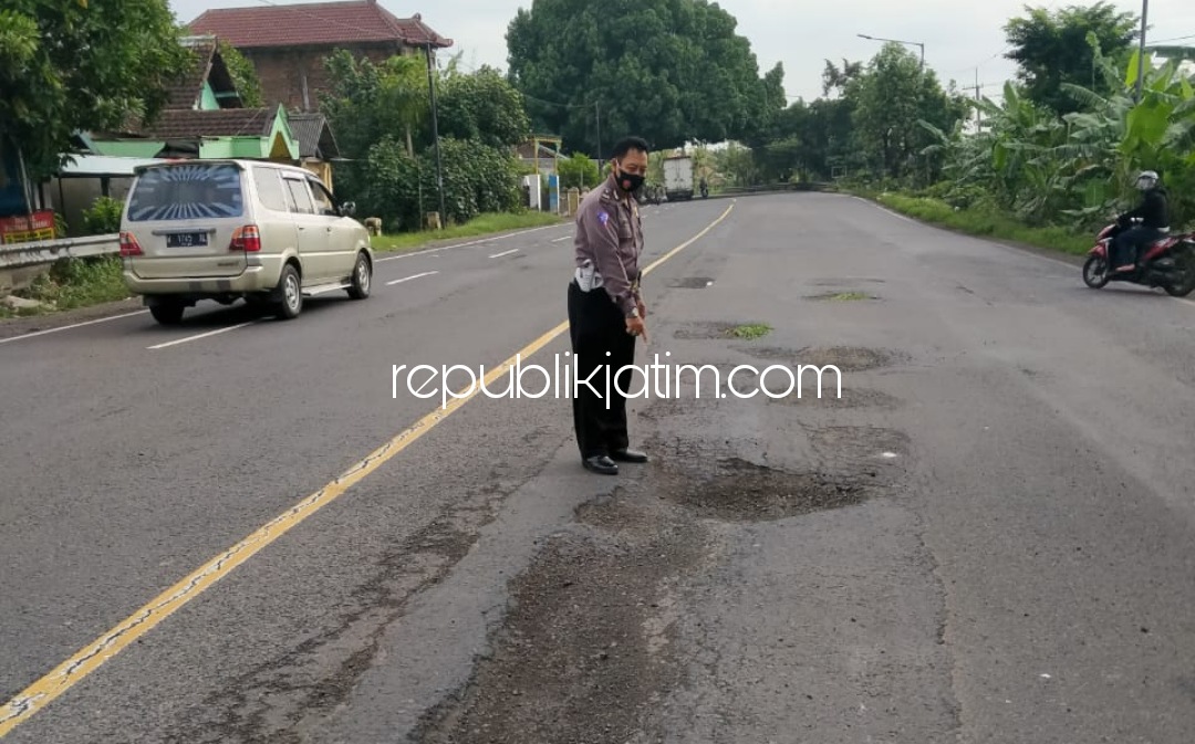 TKP - Sejumlah anggota Unit Lantas Polsek Balongbendo menunjukkan lokasi korban terjerembab jalan berlubang di jalur tengkorak JL Raya Surabaya - Mojokerto, Balongbendo, Sidoarjo, Rabu (13/01/2021).