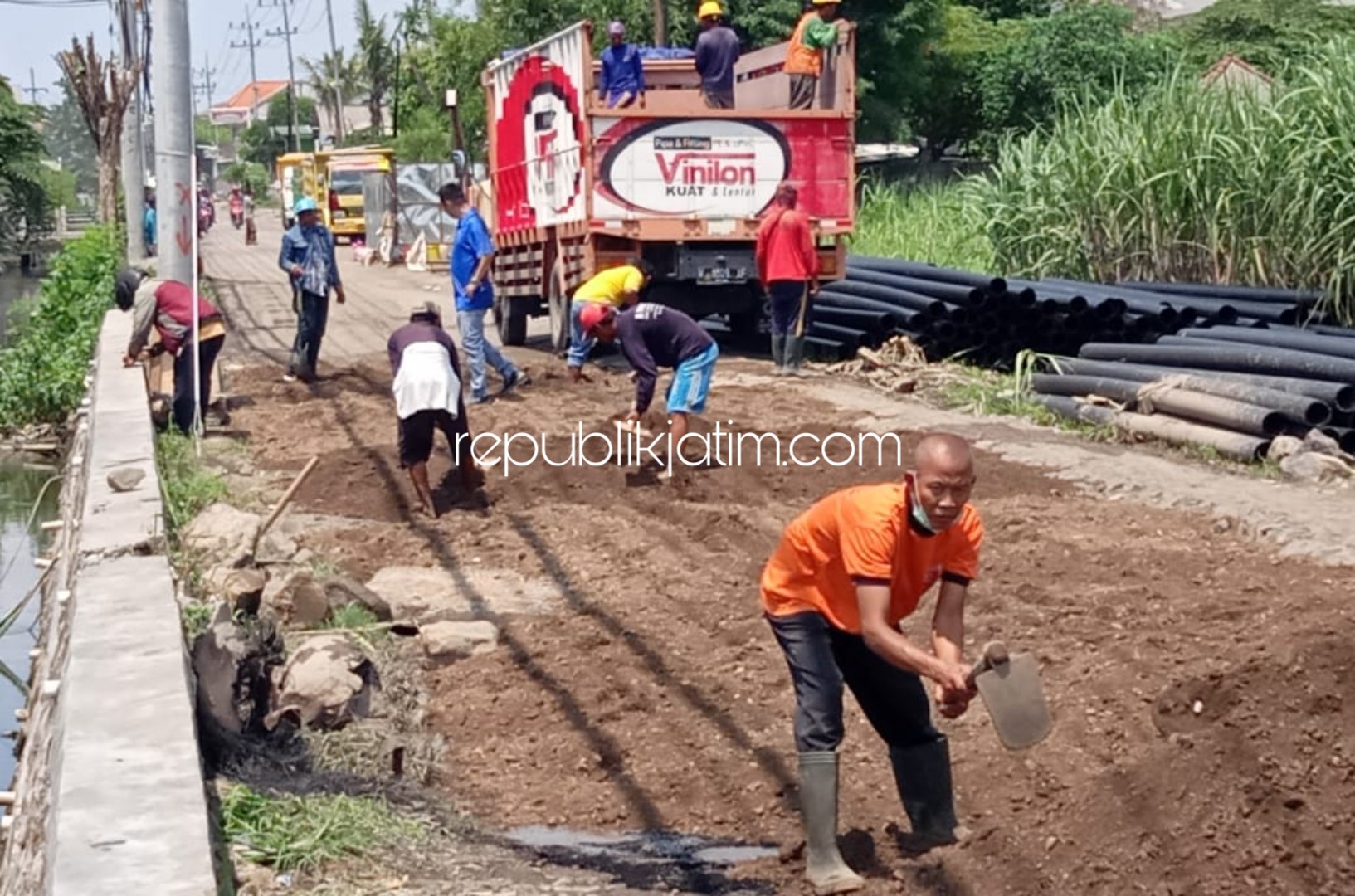 DIURUK - PT Wijaya Santosa mulai menguruk jalan rusak di Desa Barengkrajan, Kecamatan Krian, Sidoarjo dan berencana mengaspal jalan yang sempat ditanami pisang warga, Sabtu (18/01/2020).