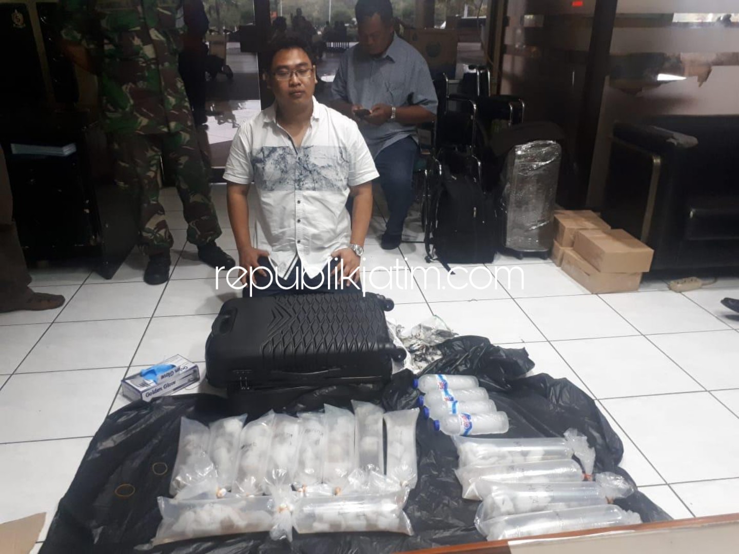 DIAMANKAN - Tersangka Erik Kurniawan (29) warga Surabaya yang diamankan Satgaspam TNI AL Bandara Juanda bersama barang buktinya, Jumat (18/01/2019).