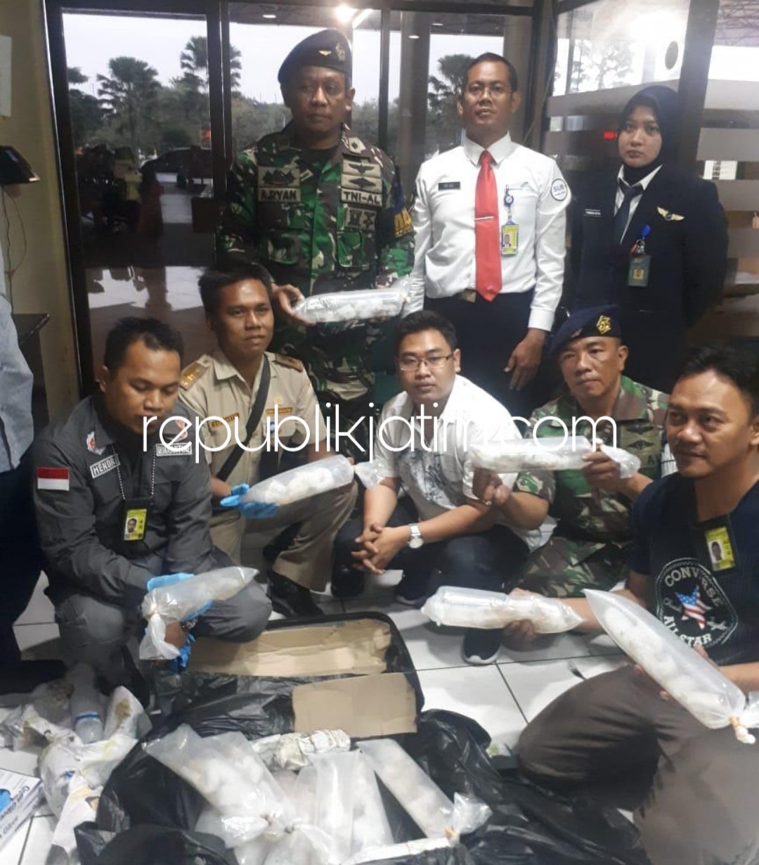 DIAMANKAN - Tersangka Erik Kurniawan dan barang bukti 3.656 ekor benih lobster diamankan petugas Satuan Tugas Pengamanan (Satgaspam) TNI AL Bandara Juanda Sidoarjo, Jumat (18/01/2019).