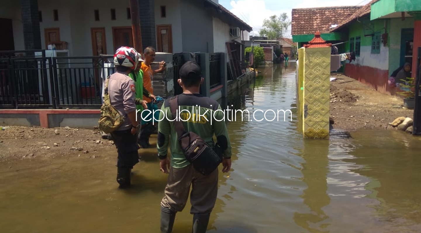 TERJUN - Anggota Polsek Tanggulangin, Aipda Puput Ardianto terjunkan ke lokasi pemukiman warga terdampak banjir dengan membantu warga membuat saluran air, Rabu (20/01/2021).