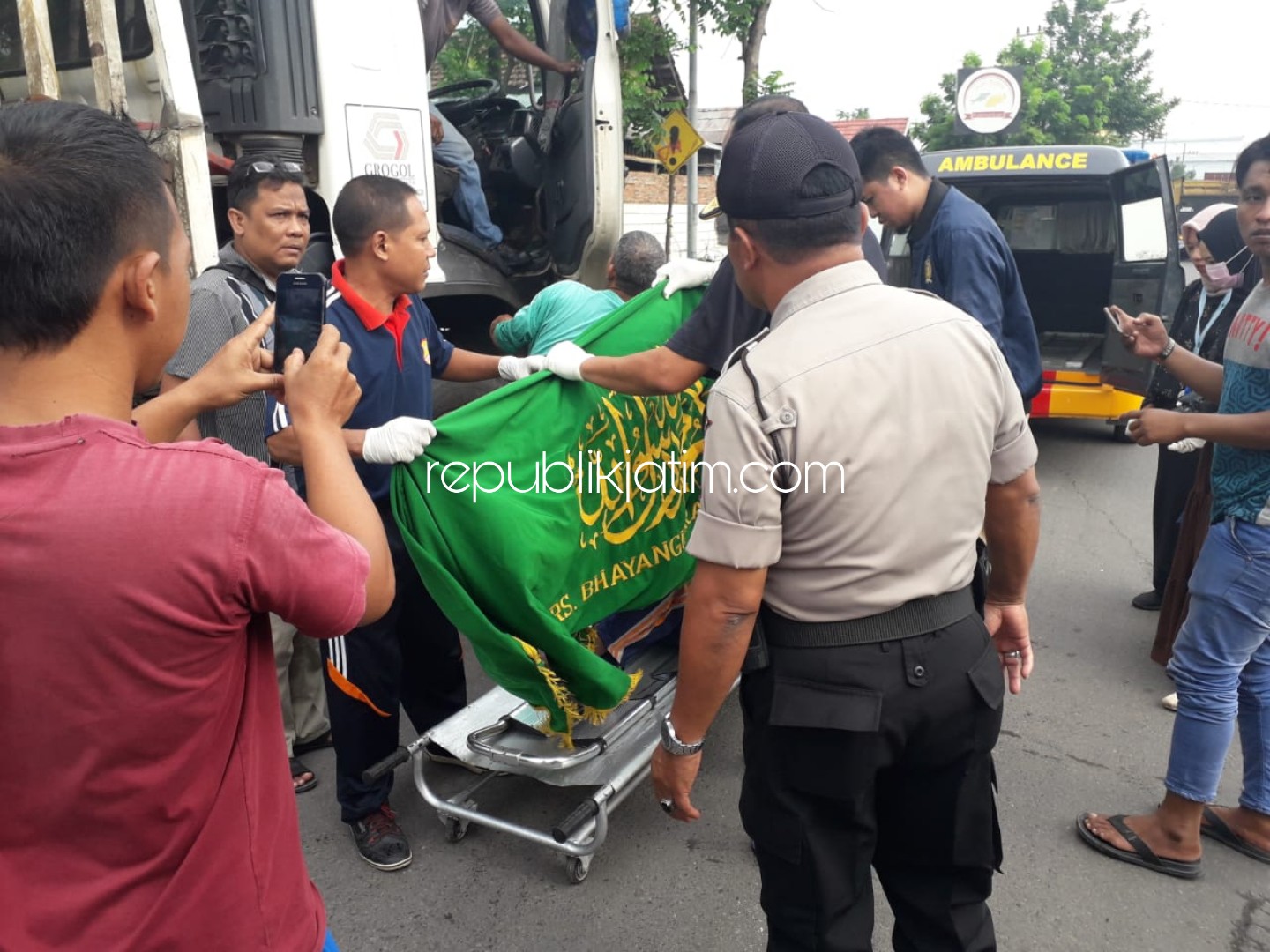 EVAKUASI - Petugas dan warga mengevakuasi jenazah Sukadi dari truk untuk dibawa ke RS Bhayangkara Pusdik Gasum Porong, Kamis (23/01/2020).