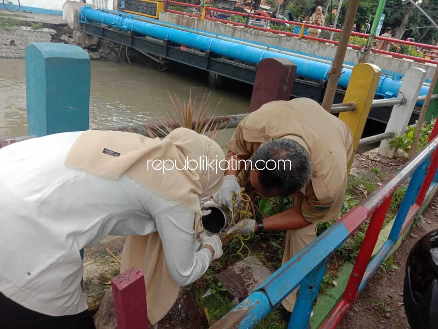 SAMPEL - Tim UPT Laboratorium Dinas Lingkungan Hidup dan Kebersihan (DLHK) Pemkab Sidoarjo mengambil sampel air dari Sungai Pucang yang diduga bau bio solar, Senin (03/02/2020).