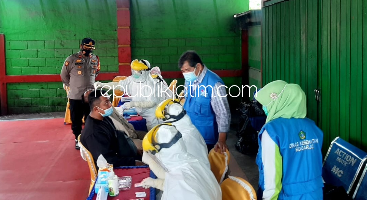 DIRAPID - Sejumlah petugas tenaga kesehatan sibuk rapid antigen warga dari luar kota Sidoarjo bersama Polsek Krian dan jajarannya di Pos By Pass Krian, Sidoarjo, Sabtu (13/02/2021).