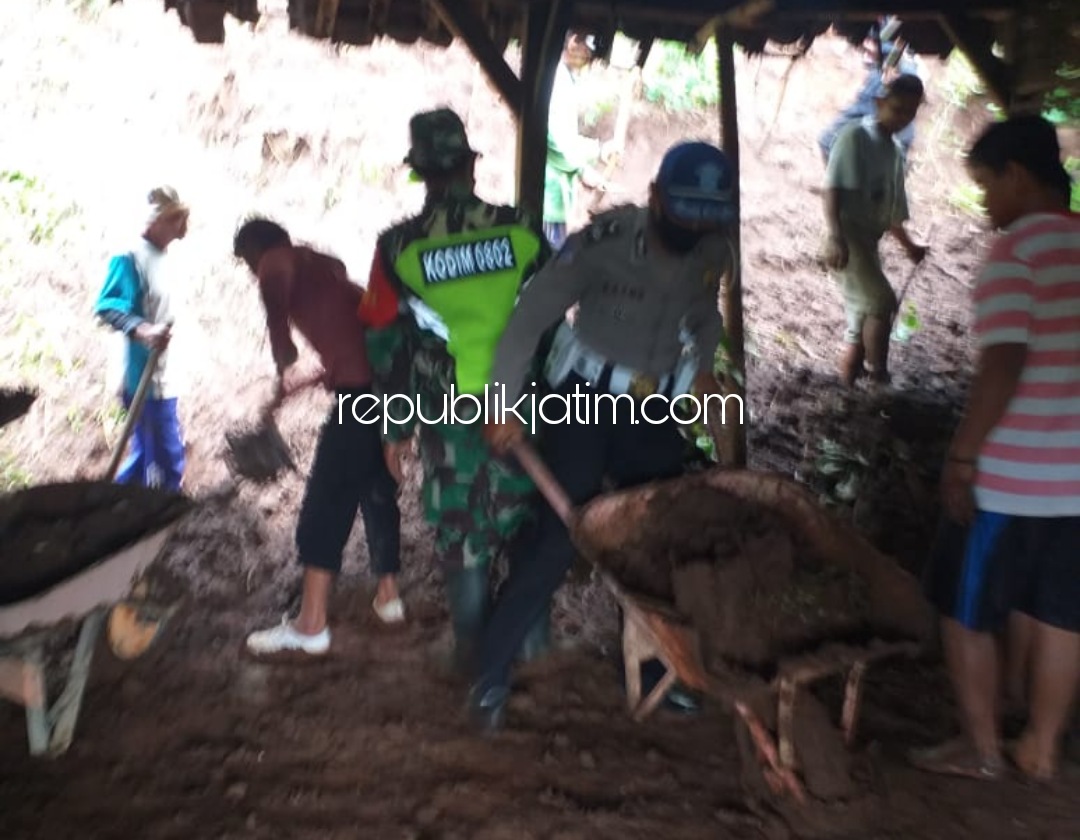 LONGSOR - Sejumlah petugas Polsek dan Koramil Pulung saat kerja bakti bersama warga membersihkan tanah longsor yang menimpa rumah Toimun (60) warga Dusun Wonorejo, Desa Serak, Kecamatan Pulung, Ponorogo, Senin (15/02/2021). 