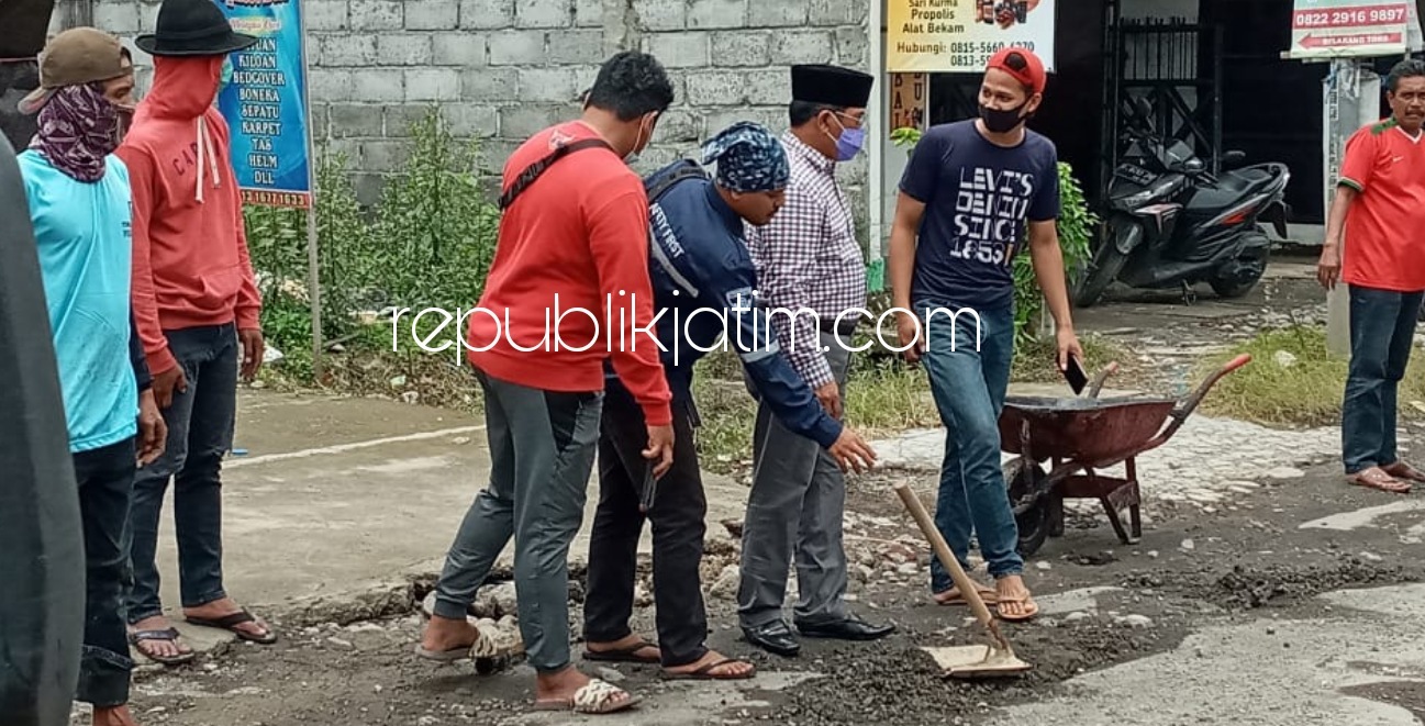 TAMBAL JALAN - Warga Desa Rangkahkidul, Kecamatan Sidoarjo memperbaiki jalan berlubang di desanya secara gotong royong dan sukarela tanpa menunggu perbaikan dari Pemkab Sidoarjo yang kerapkali molor, Sabtu (20/02/2021).