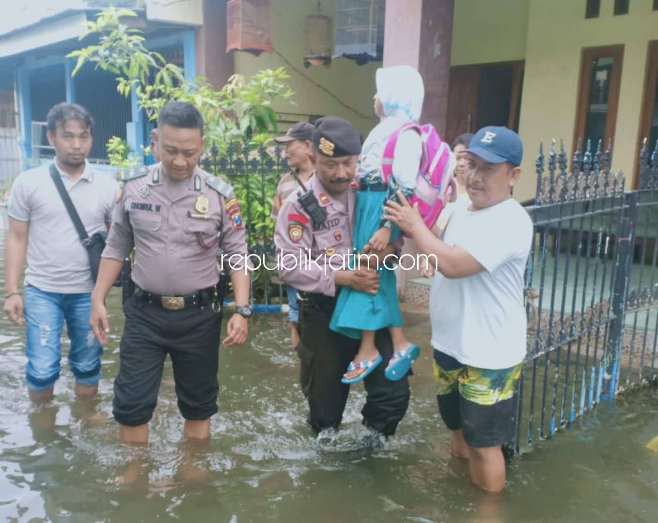 EVAKUASI - Sejumlah anggota Polsek Taman sibuk mengevakuasi para siswa yang hendak berangkat sekolah di Desa Kramatjegu, Kecamatan Taman, Sidoarjo, Rabu (26/02/2020).