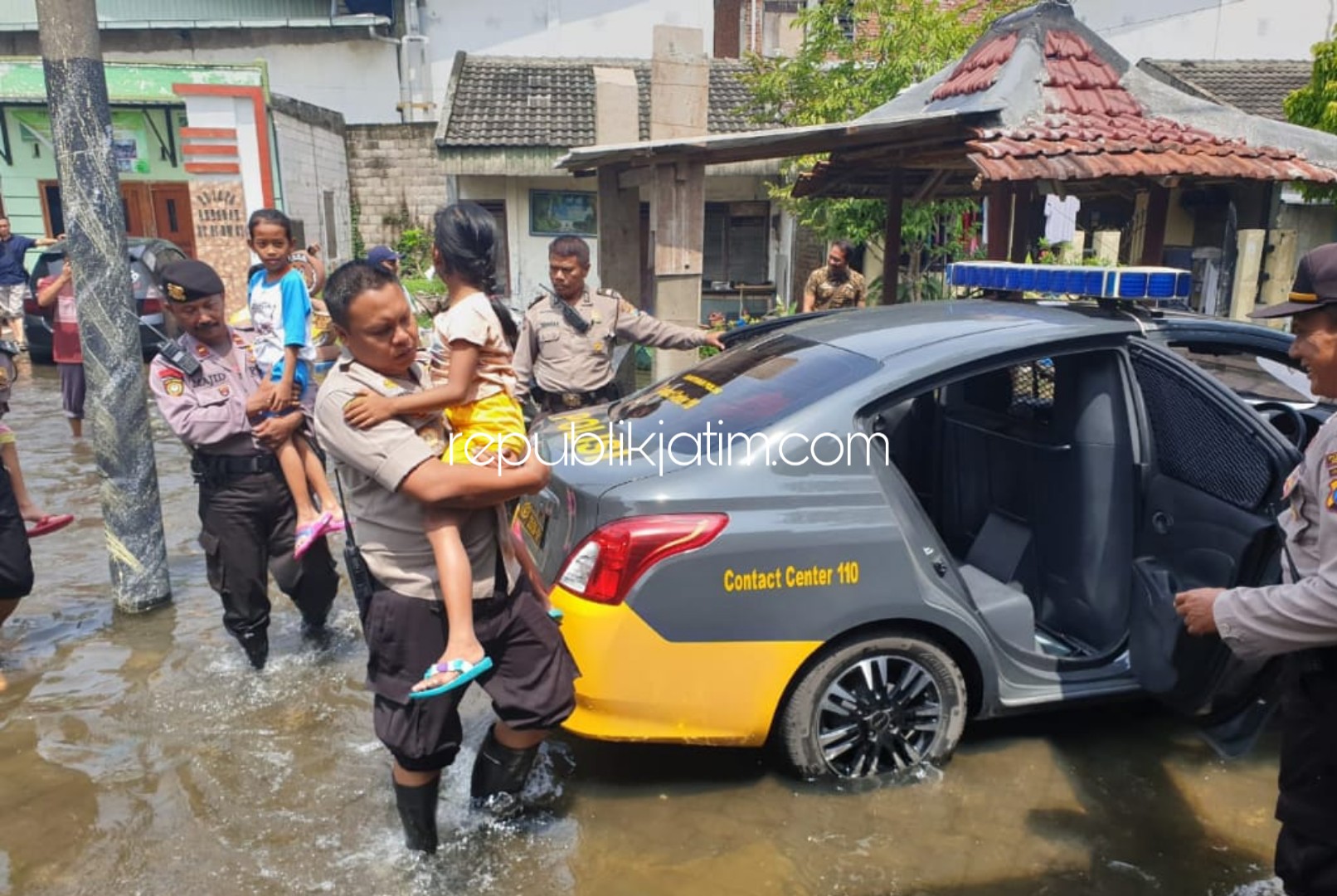 EVAKUASI - Sejumlah anggota Polsek Taman mengevakuasi korban banjir di Perumahan Pejaya Anugerah Desa Kramatjegu, Kecamatan Taman, Sidoarjo, Rabu (26/02/2020). 