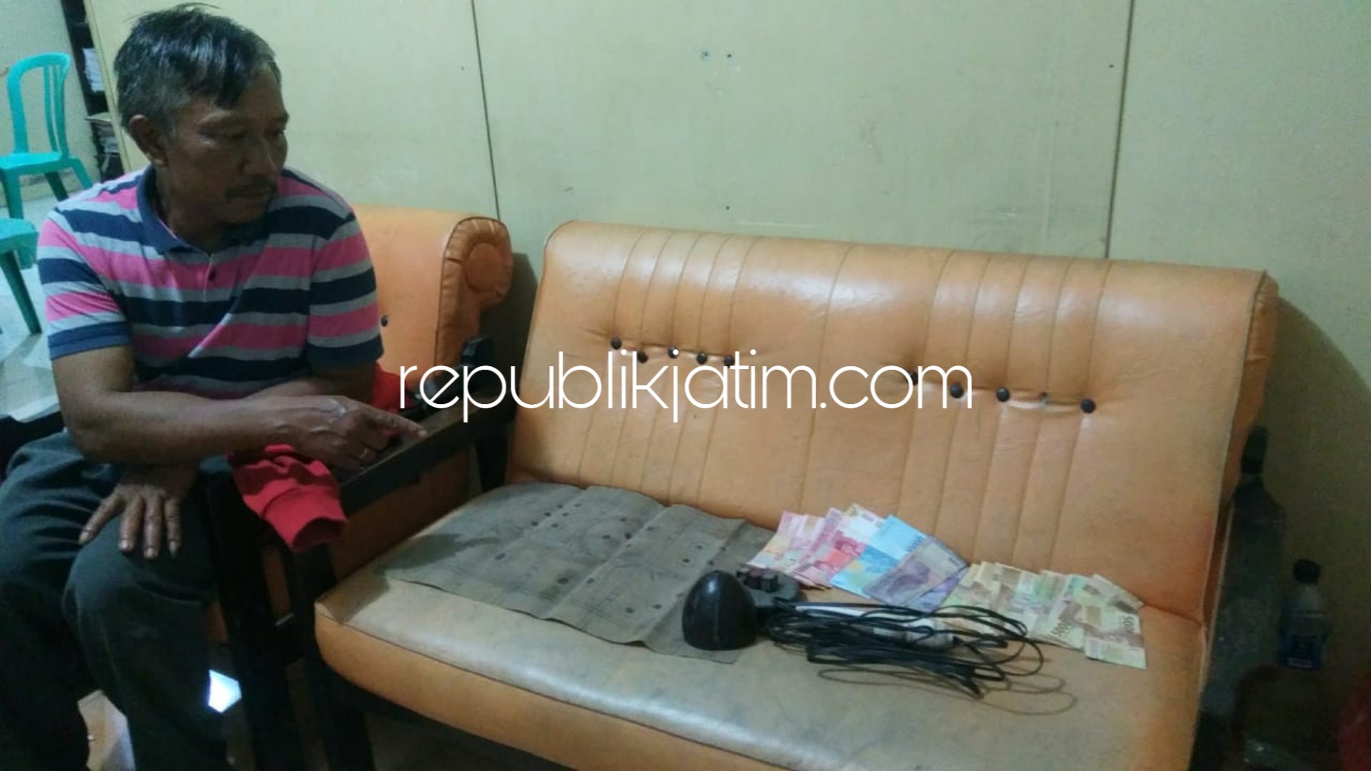 BARANG BUKTI - Petugas Polsek Sambit menunjukkan barang bukti hasil penggerebekan judi dadu kopyok di Dusun Ngrancah, Desa Gajah, Kecamatan Sambit, Ponorogo, Rabu (27/02/2019).