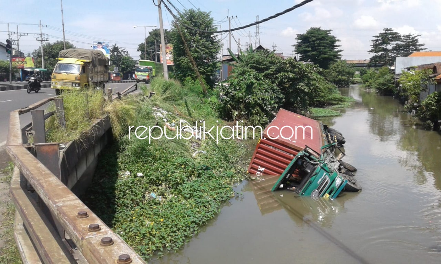 TERJUN - Sebuah truk trailer bernopol L 9258 UP yang dikemudikan Teguh (47) terjun bebas ke dalam Sungai perbatasan Desa Ketegan, Kecamatan Taman dan Desa Madaeng, Kecamatan Waru, Sidoarjo diduga karena sopir mengantuk, Kamis (28/02/2019).
