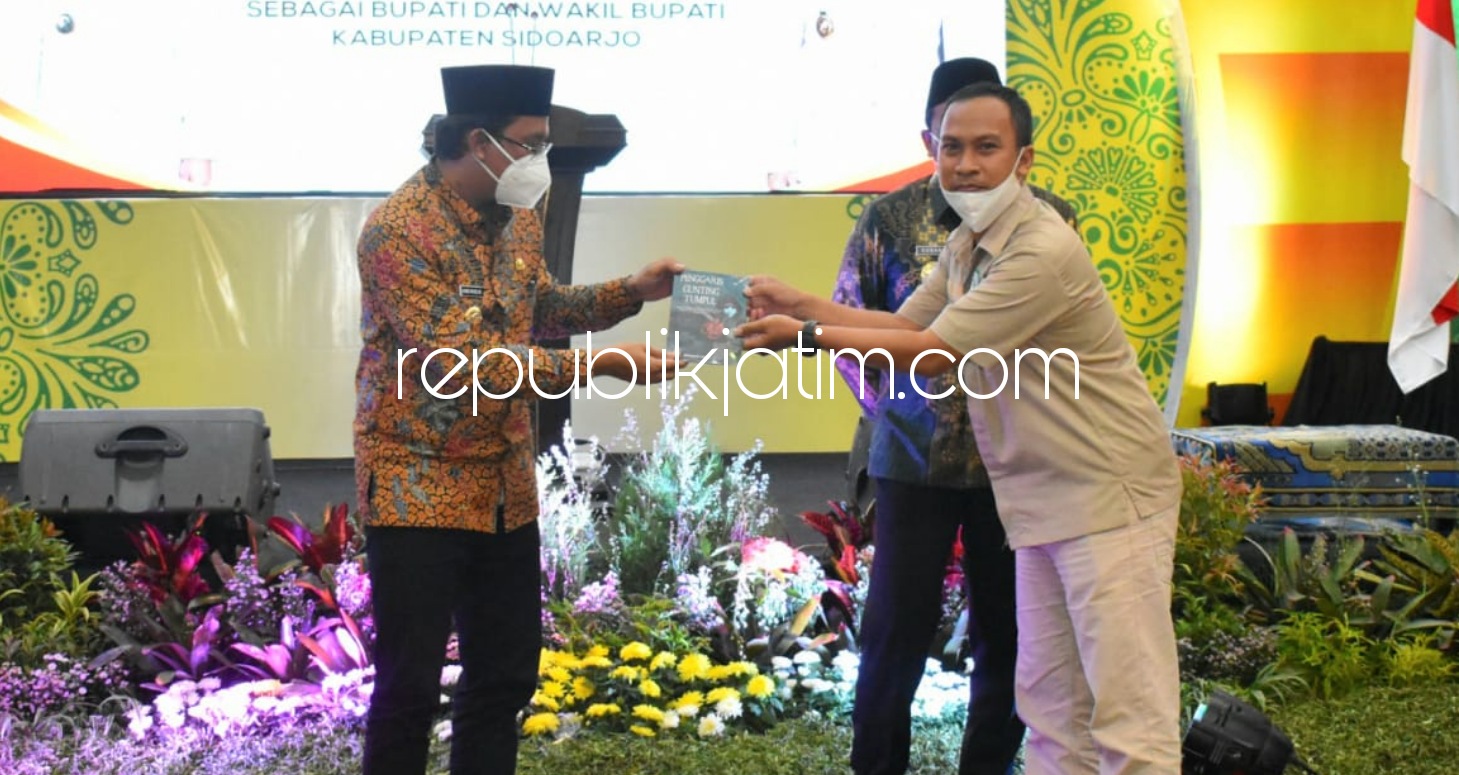 HADIAH - Penulis buku Penggaris dan Gunting yang Tumpul, Akhmad A Fahmi menyerahkan buku berkisah perjalanan merebut hati pemilih Sidoarjo kepada Bupati dan Wabup Sidoarjo, Ahmad Muhdlor Ali dan Subandi dalam acara tasyakuran, Minggu (01/03/2021) malam.