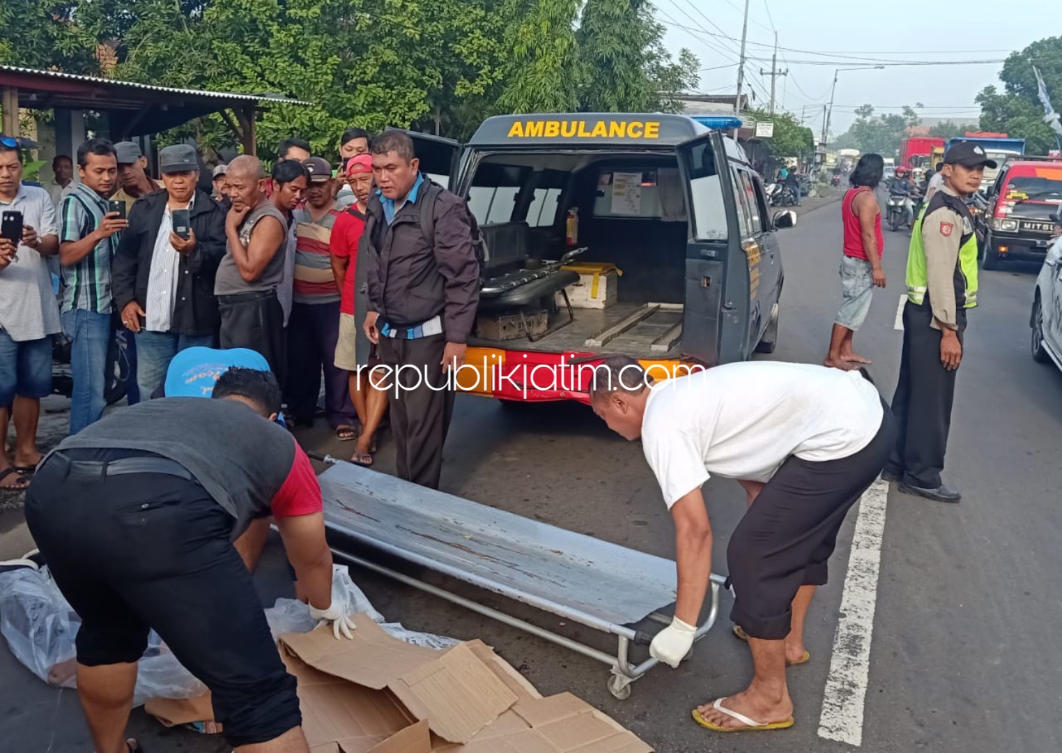 EVAKUASI - Sejumlah petugas dan warga mengevakuasi jenazah pelajar, Ahmad Jamaluddin Mahfud (17) pelajar Asal Desa Kedungsolo, Kecamatan Porong yang terlindas truk di JL Raya Porong - Krembung, Sidoarjo, Sabtu (07/03/2020).
