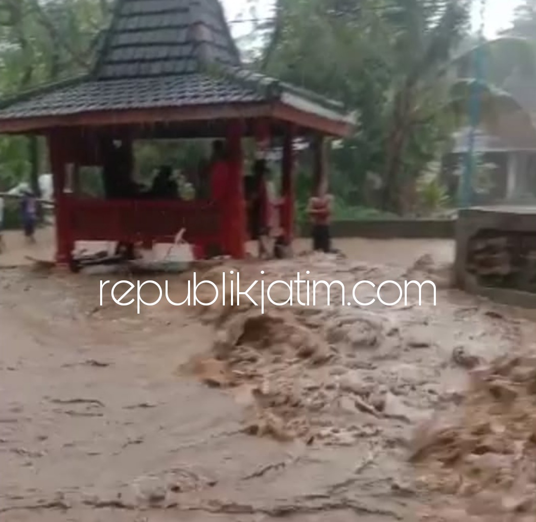 BANJIR - Petugas BPBD Pemkab Ponorogo dan tiga pilar desa langsung membersihkan lumpur di Jalan Desa Duri, Kecamatan Slahung, Ponorogo usai banjir, Minggu (07/03/2021) sore. 