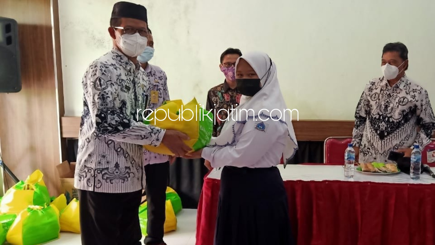 SERAHKAN - Ketua PGRI Sidoarjo, Edy Wuryanto menyerahkan bantuan 467 paket sembako untuk pelajar korban banjir di SMPN 2 Tanggulangin, Sidoarjo, Selasa (16/03/2021).
