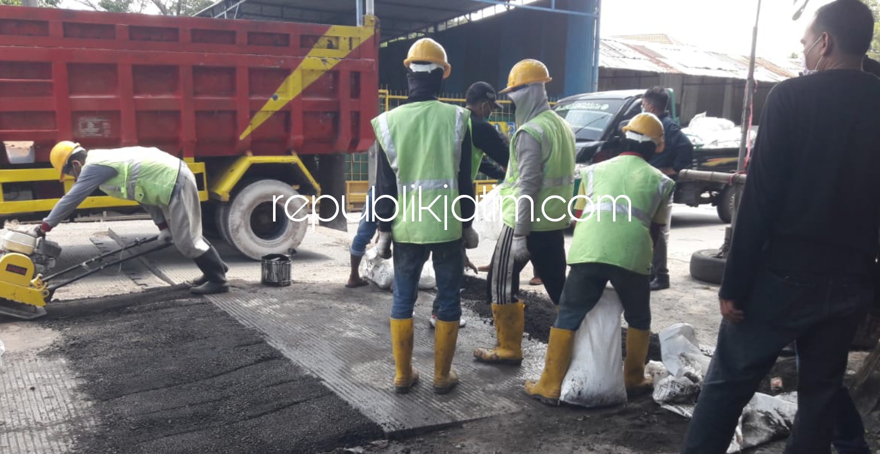 DIPERBAIKI - Jalan rabat beton di pertigaan Kemangsen, Kecamatan Krian menuju Rumah Potong Hewan (RPH) Krian yang ambles dan melingkap diperbaiki dengan ditambal aspal, Jumat (19/03/2021).