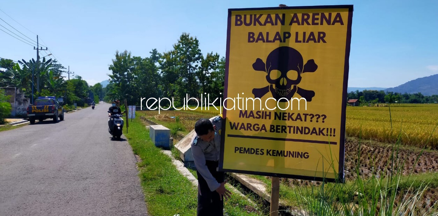 BANNER - Petugas Polsek Sambit memasang sejumlah banner larangan balap liar yang meresahkan masyarakat Sambit di sepanjang JL Raya menuju Waduk Bendo, Jumat (19/03/2021).