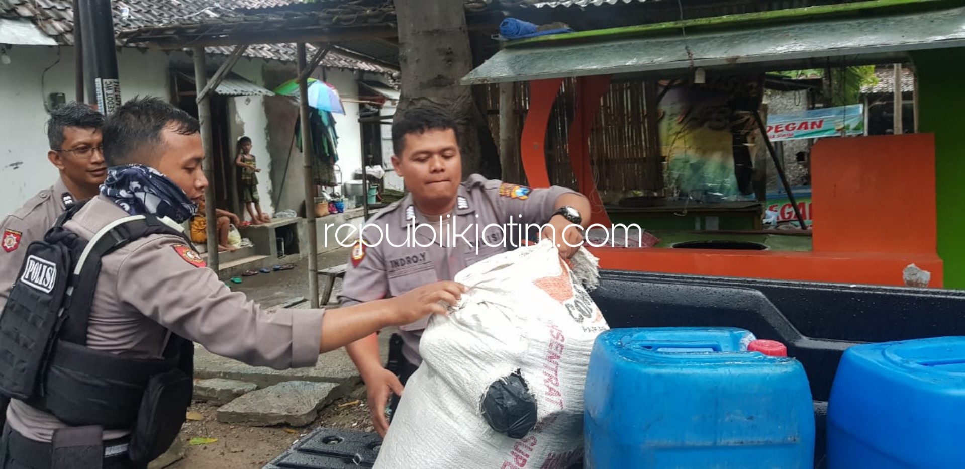 MIRAS - Petugas Sabhara Polres Ponorogo mengangkut barang bukti berupa arak jowo (arjo) yang dikemas dalam botol bekas air mineral dan jerigen dari dua tersangka penjual miras, Kamis (19/03/2020).