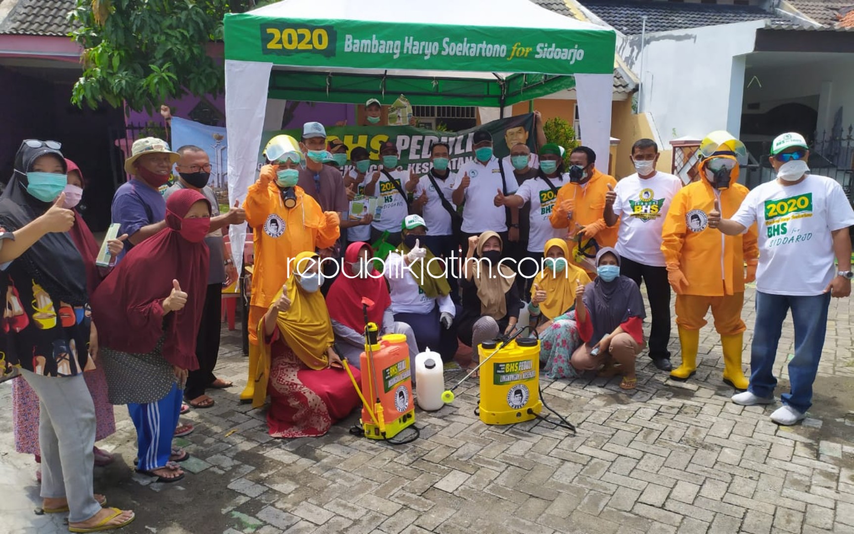 SEMPROT - Sejumlah tim Bacabup Sidoarjo, Bambang Haryo Soekartono (BHS) menyemprotkan disinfektan dan membagikan ratusan masker ke warga RW 11, Perumahan Mutiara Citra Asri (MCA) Desa Sumorame, Kecamatan Candi, Sidoarjo, Selasa (24/03/2020).