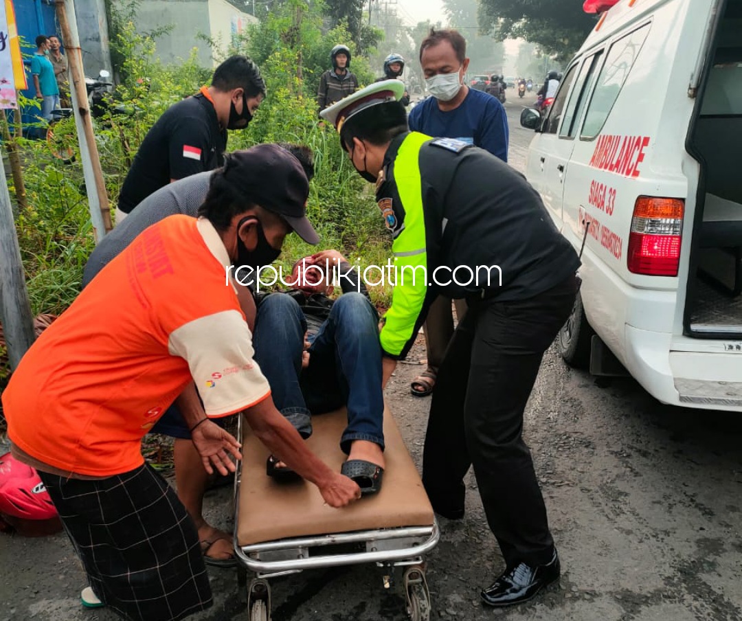 EVAKUASI - Kanit Lantas Polsek Balongbendo, Iptu Rohmat Basuki bersama anggota dan warga mengevakuasi korban kecelakaan dua motor lawan truk di JL Raya Dusun Sirapan, Desa Kemangsen, Kecamatan Balongbendo, Sidoarjo, Kamis (25/03/2021).