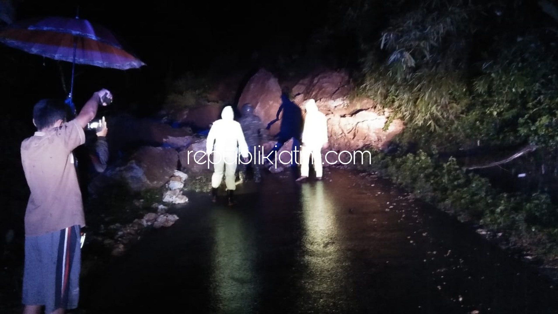 LONGSOR TUTUP JALAN - Sebuah alat berat mengevakuasi bongkahan batu besar dan lumlur yang menutup badan jalan antar Kabupaten Ponorogo - Kabupaten Trenggalek, Rabu (25/03/2020).