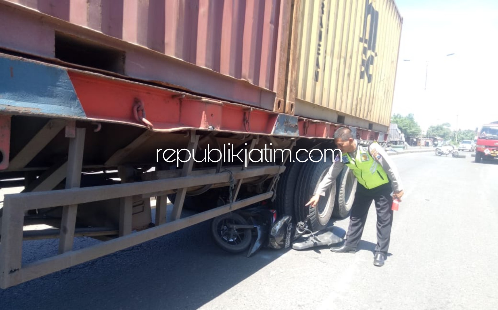 TERLINDAS - Para pengguna jalan mengevakuasi jenazah pengendara motor korban kecelakaan yang dilindas truk kontainer di JL By Pass Krian, Desa Barengkrajan, Kecamatan Krian , Sidoarjo, Kamis (26/03/2020).