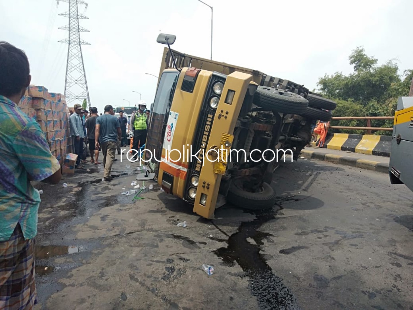 TERGULING - Sebuah truk bernopol S 8279 UH yang dikemudikan Sojo (54) warga Karangsari, Tuban terguling lantaran as roda putus di jalur Arteri Porong, Dusun Kluwih, Desa Kebonagung, Kecamatan Porong, Sidoarjo, Selasa (02/04/2019).
