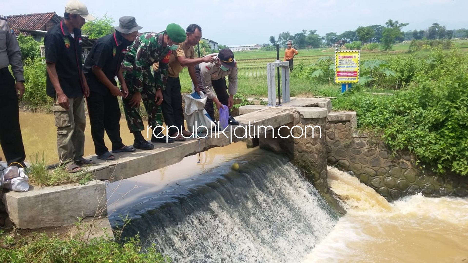 BANNER LARANGAN - Warga dan aparat memasang banner larangan pembuangan sampah ke sungai dan melepas benih ikan lele ke Sungai Jetis, Ponorogo, Kamis (02/04/2020).