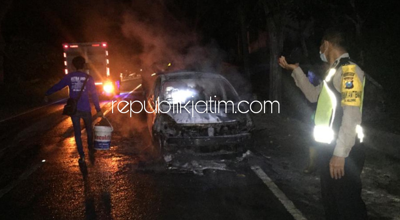 TERBAKAR - Petugas saat memadamkan api yang membakar mobil milik warga Sidoarjo di jalur Ponorogo - Pacitan, Minggu (04/04/2021) dini hari.