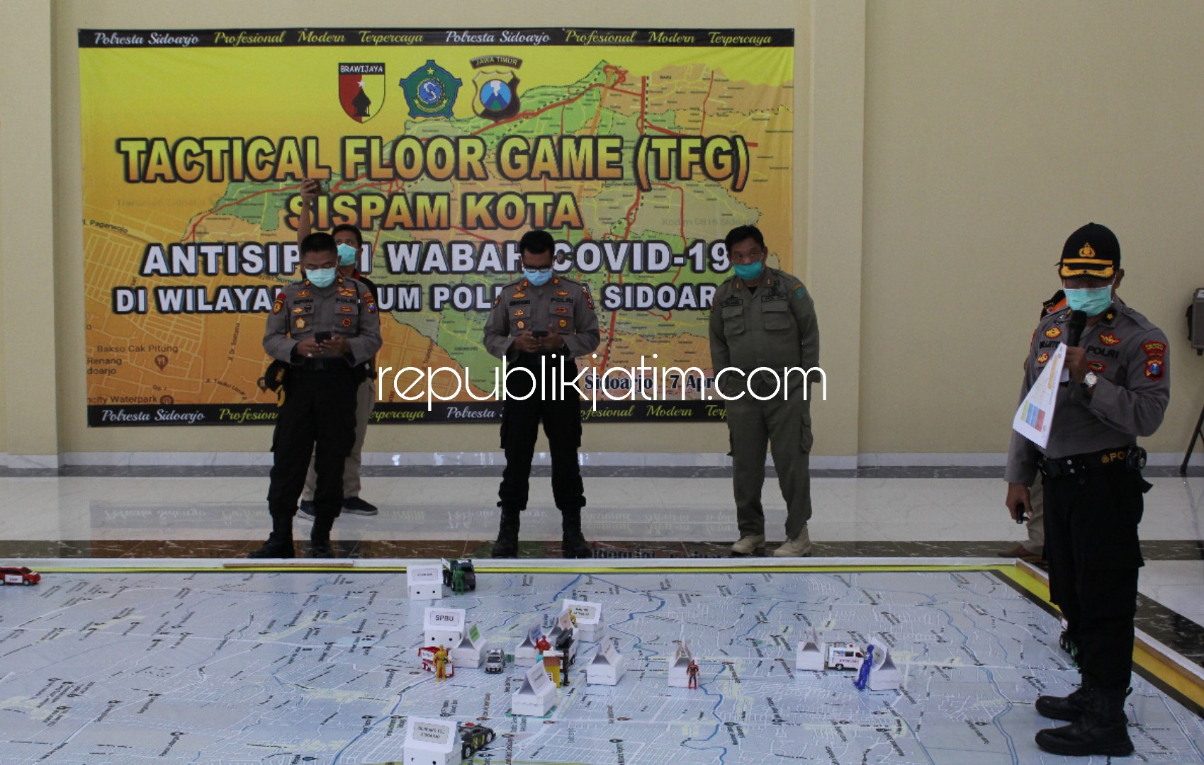 PENJELASAN - Kabag Ops Polresta Sidoarjo memberikan penjelasan kepada semua pihak soal Tactical Floor Game (TFG) sebagai antisipasi penyebaran virus Corona (Covid-19), Selasa (07/04/2020) sore.