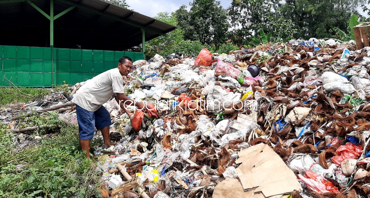 MENUMPUK - Petugas kebersihan (pungut) sampah Pasar Surungan, Desa Penambangan, Kecamatan Balongbendo, Slamet saat di tumpukan sampah basah dan kering yang bercampur di TPST, Kamis (08/04/2021). 