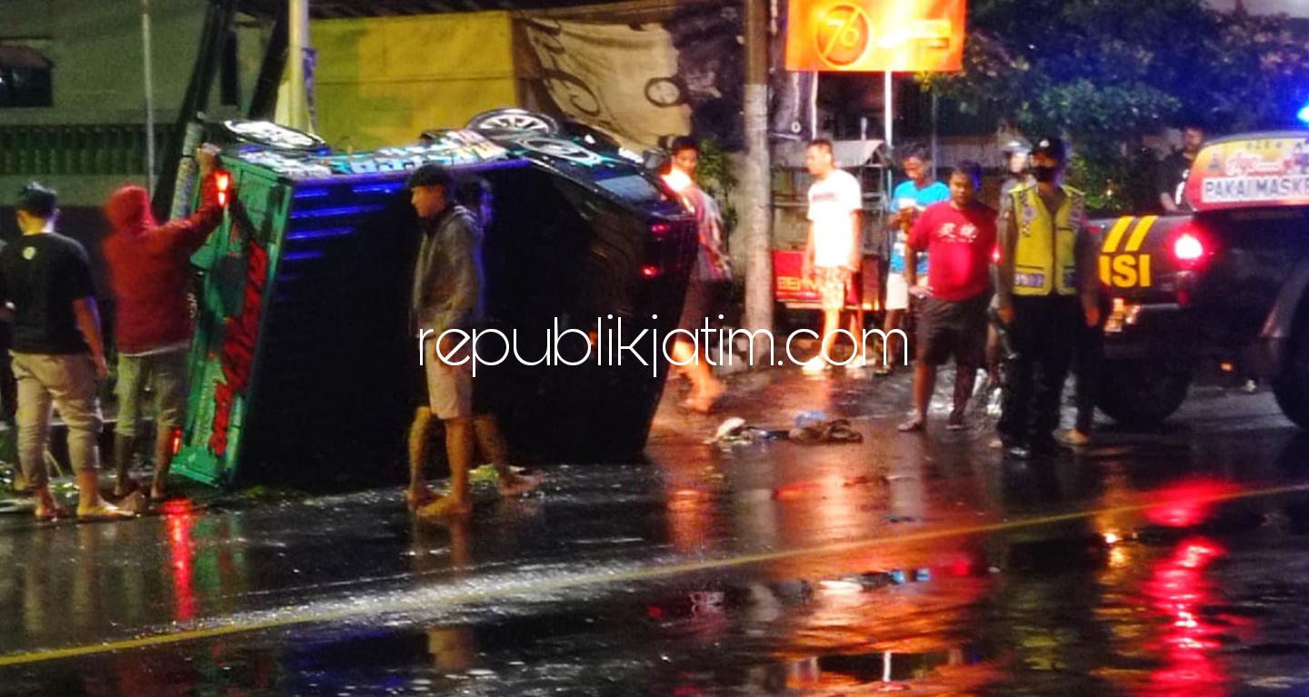 TERBALIK - Petugas mengevakuasi mobil pikup yang terbalik di atas trotoar setelah menghantam pengendara motor di perempatan Jetis, Ponorogo, Minggu (11/04/2021) dini hari.