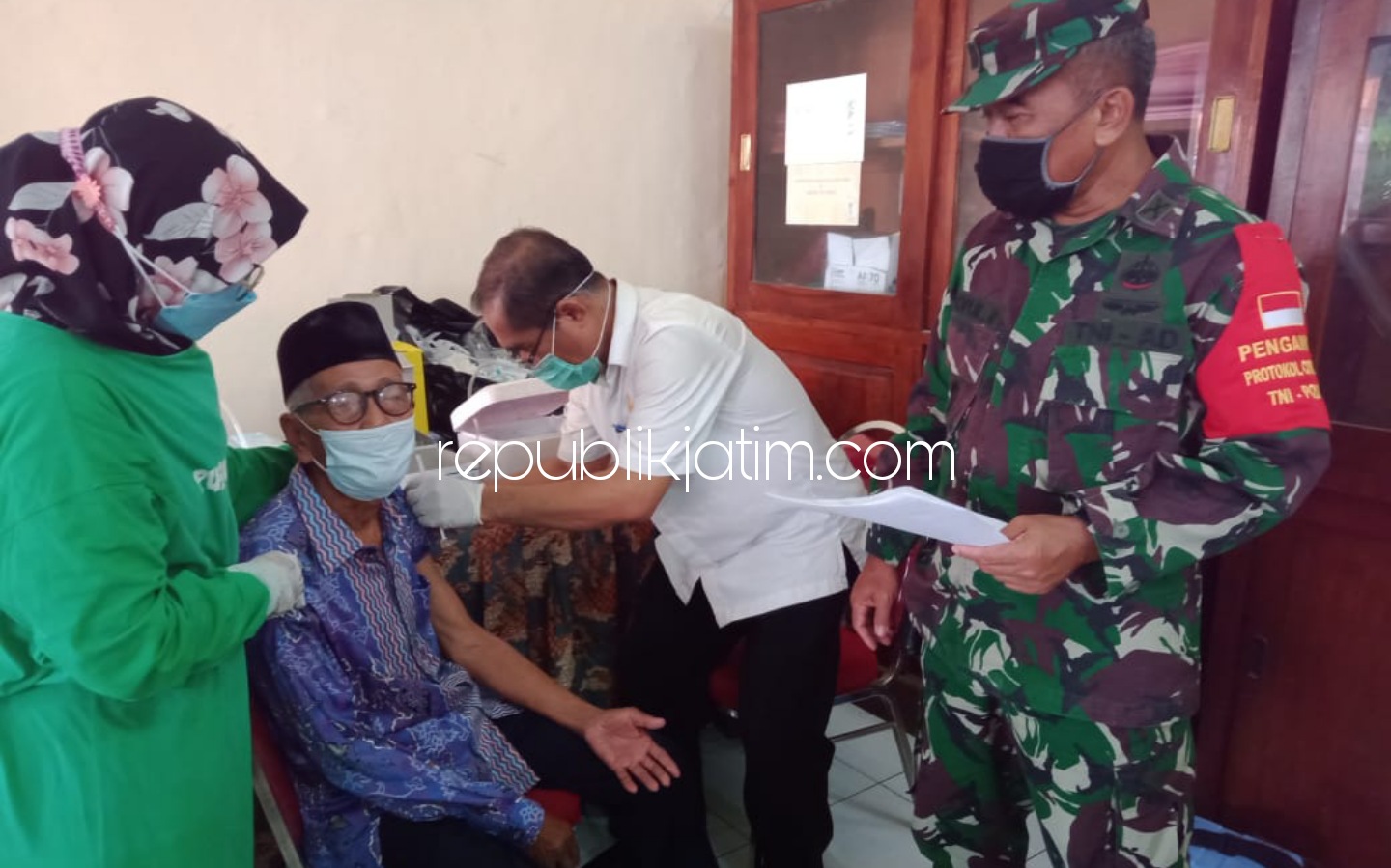 VAKSINASI - Sumono (60) warga Desa Balongmacekan, Kecamatan Tarik saat menyuntikkan vaksin Astra Zeneca di kantor desa setempat, Sabtu (17/04/2021).