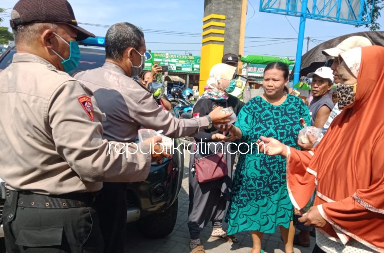 BAGIKAN NASI - Petugas Polsek Krembung membagikan 200 nasi bungkus hasil masakan di Posko Dapur Umum Covid-19 yang ada di Polsek Krembung, Sabtu (18/04/2020).