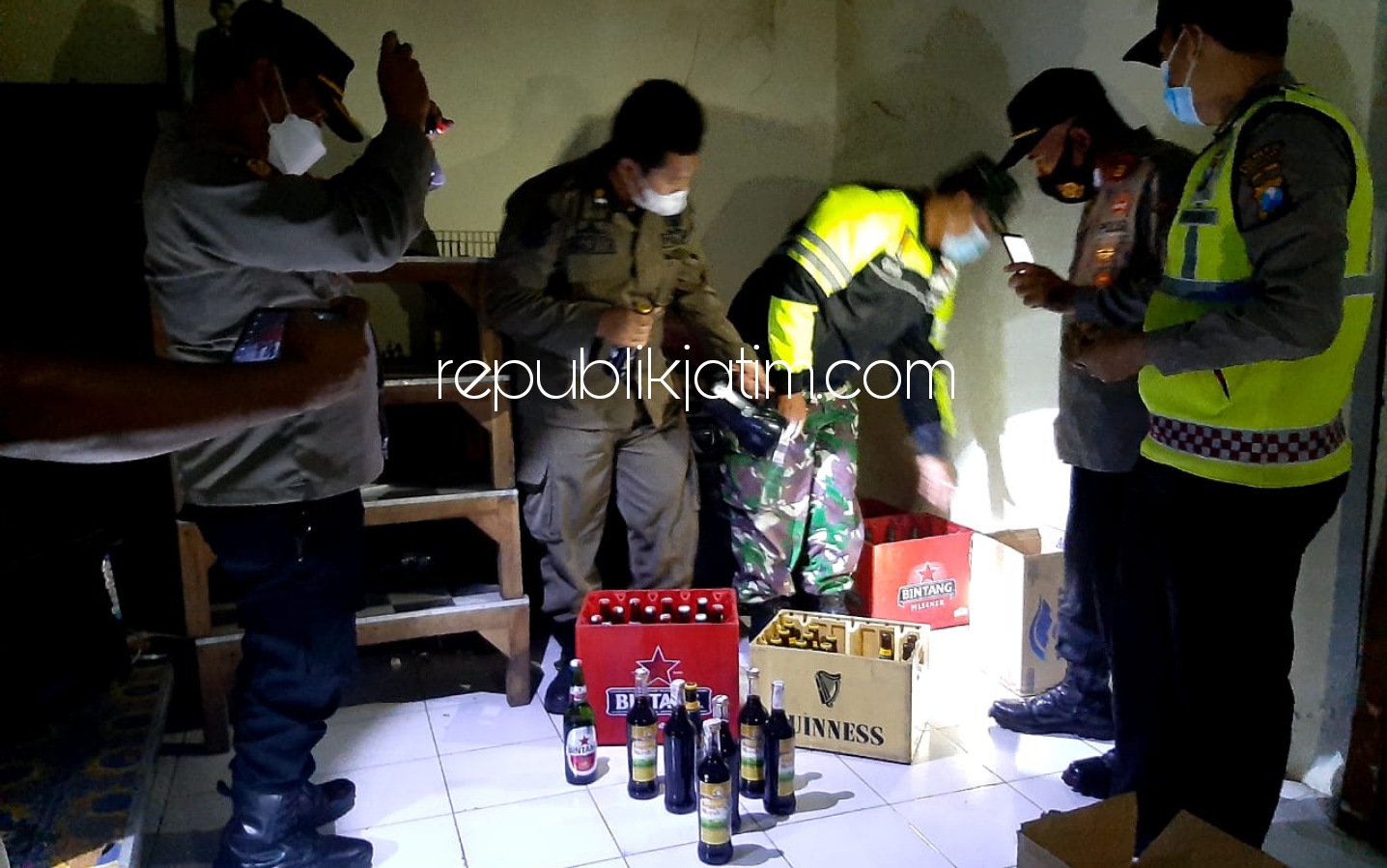 SITA MIRAS - Para petugas gabungan yang dipimpin Kapolsek Krian, Kompol Mukhlason merazia miras di sejumlah titik lokasi, Minggu (18/04/2021) malam.