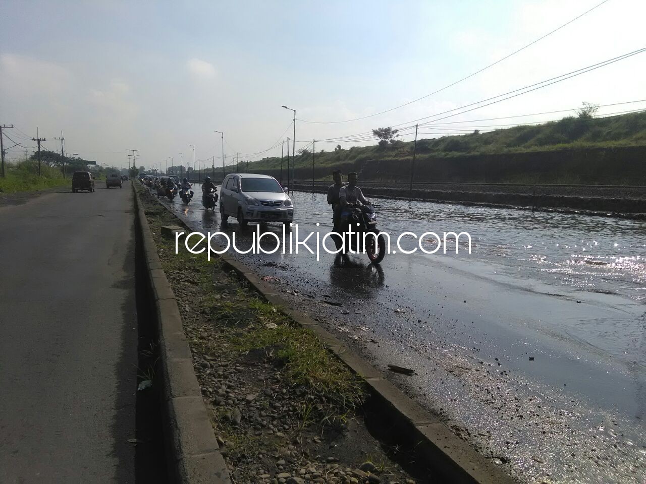 TERGENANG - Kendati tidak ada hujan deras dan makan waktu berjam-jam akan tetapi JL Raya Porong tepat di Depan Tanggul Lumpur Sidoarjo tetap tergenang air setinggi 30 sentimeter, Jumat (20/04/2018).