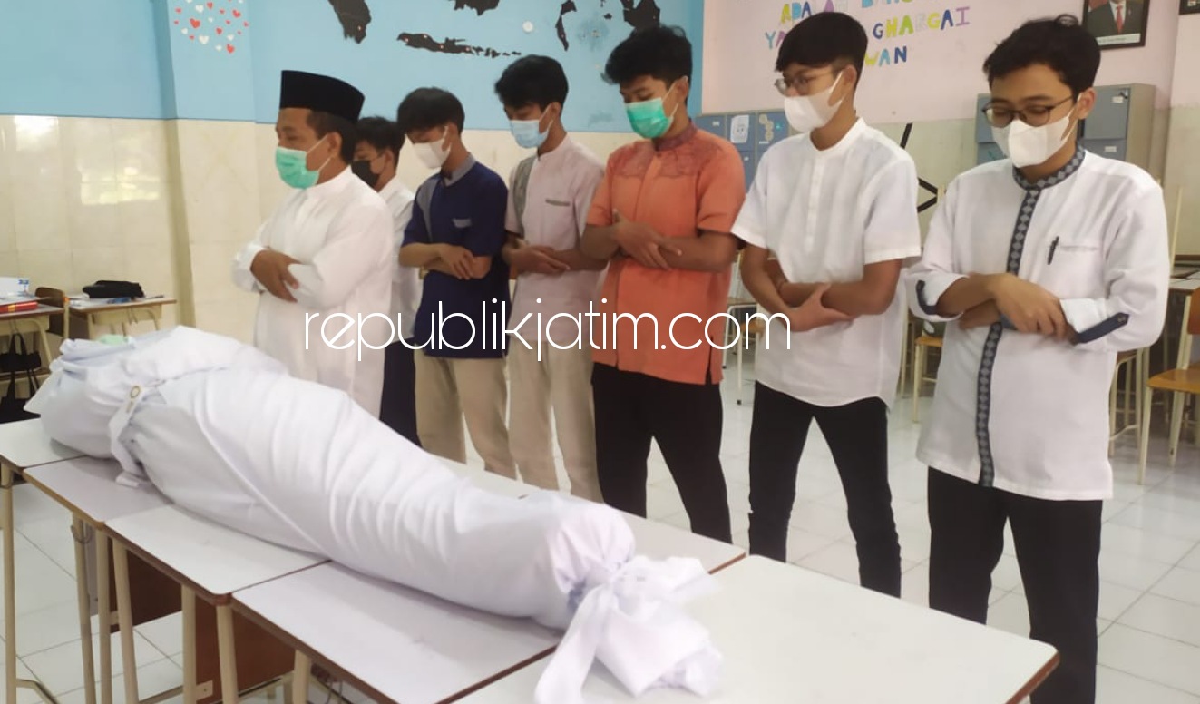 MENGKAFANI - Para siswa kelas XI SMA Muhammadiyah 2 (Smamda) Sidoarjo diajari mengkafani jenazah dan merawatnya hingga ke pemakaman saat praktek Baitul Arqom, Jumat (23/04/2021).