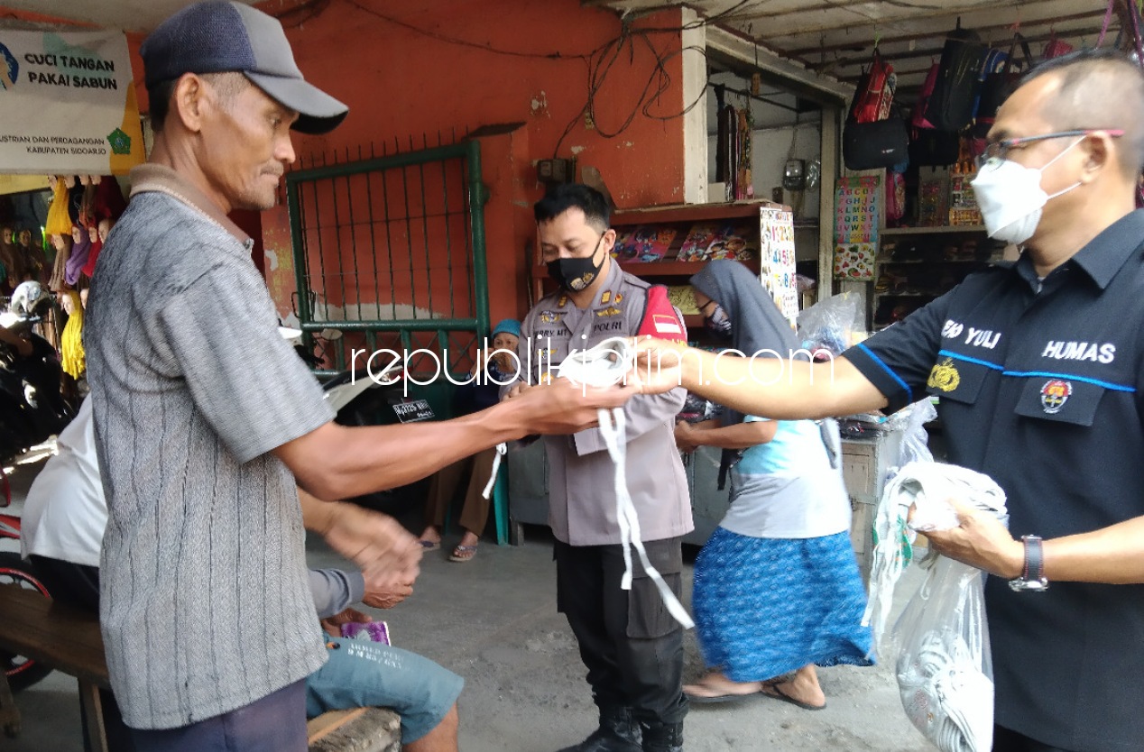 BAGIKAN - Para personil Polresta Sidoarjo membagikan 50.000 masker di sejumlah wilayah Sidoarjo sekaligus sosialisasi protokol kesehatan, Kamis (29/04/2021).