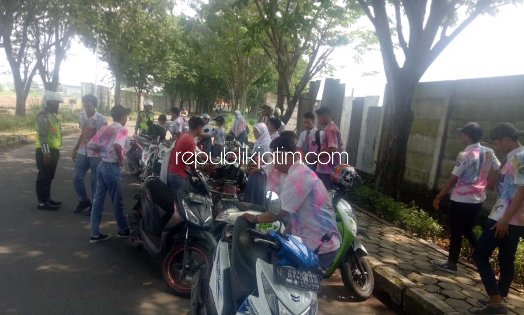 DIBUBARKAN - Sejumlah petugas Satuan Lantas Polresta Sidoarjo memeriksa kelengkapan surat dan kendaraan para pelajar yang hendak merayakan kelulusan ke Trawas, Mojokerto, Selasa (30/04/2019).