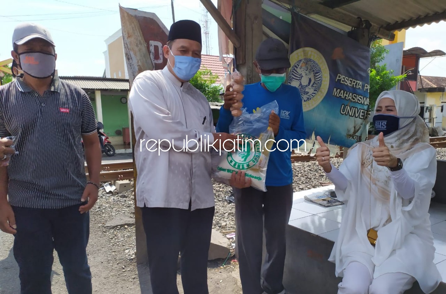 SANTUNAN - Bacabup Sidoarjo, Bambang Haryo Soekartono memberikan sembako ke penjaga pintu perlintasan, penarik gerobak sampah dan janda miskin di Kelurahan Pucang, Sidoarjo, Senin (04/05/2020).