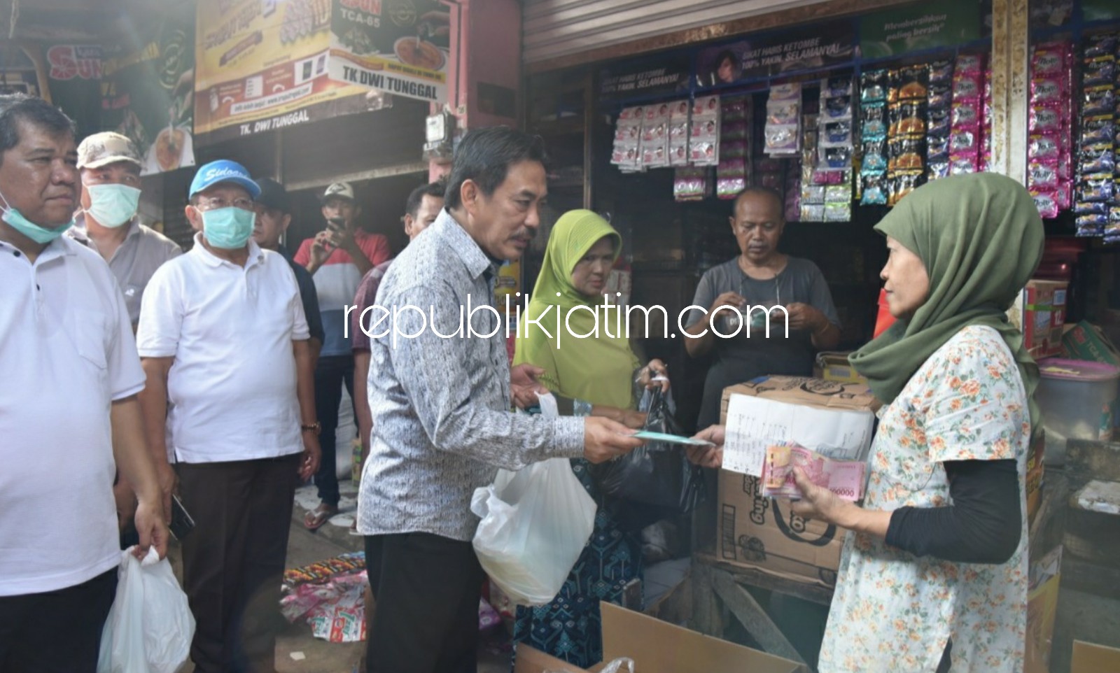 BAGI MASKER - Pejabat Pemkab Sidoarjo saat membagi-bagikan masker ke para pedagang dan pengunjung Pasar Larangan, Kecamatan Candi, Sidoarjo beberapa pekan lalu kini ada pedagang positif dirawat di rumah sakit dan rapid test 79 pedagang 4 reaktif Covid-19.