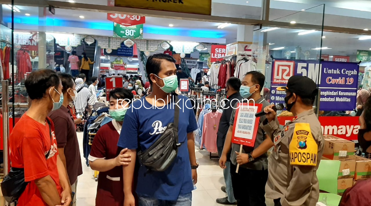 PENYEKATAN - Petugas Polsek Krian melakukan penyekatan warga yang masuk ke salah satu mall yang ada di Pasar Krian, Sidoarjo, Sabtu (08/05/2021) malam.